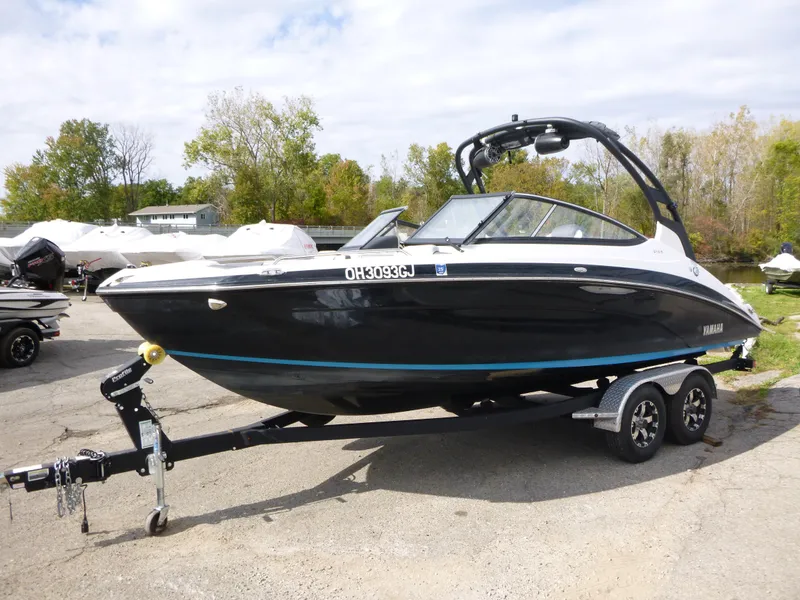 Slide: The Image of 2021 Yamaha Boats 212S on trailer, black and white design, parked outdoors. - 5