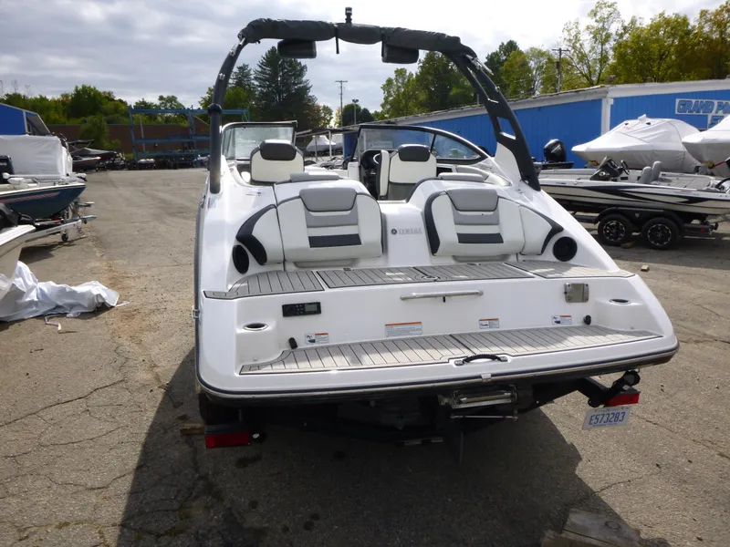 Slide: The Image of 2021 Yamaha Boats 212S, rear view, parked in a boatyard. - 7