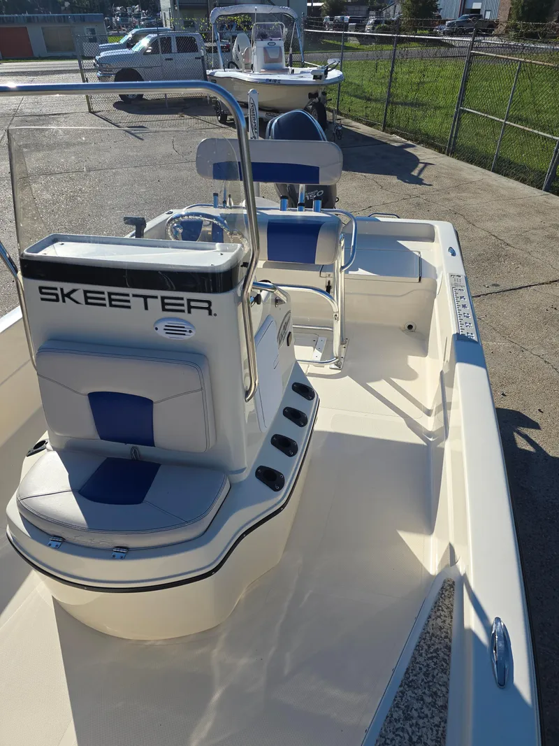 Slide: The Image of 2009 Skeeter ZX 20 Bay boat with blue and white seating, docked outdoors. - 14