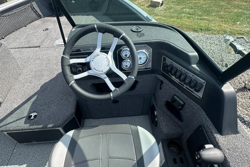Slide: The Image of 2025 Lund 1775 Impact XS Sport boat cockpit with steering wheel and control panel. - 15