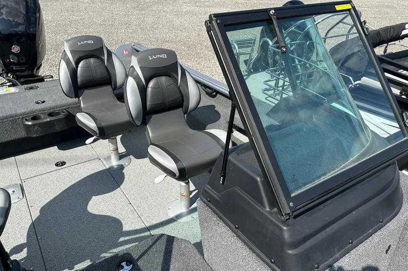 Slide: The Image of 2025 Lund 1775 Impact XS Sport boat interior with seats and windshield. - 17