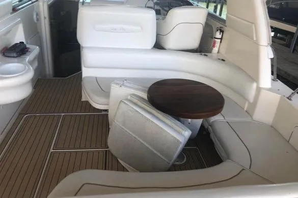 Slide: The Image of 1998 Sea Ray 310 boat interior with white seating and wooden table. - 10