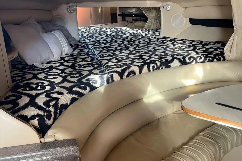Slide: The Image of Interior of 1998 Sea Ray 310 boat with patterned bedding and leather seating. - 14