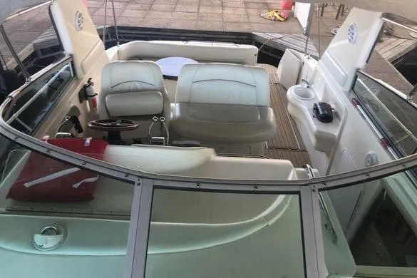 Slide: The Image of 1998 Sea Ray 310 boat interior with white seating and steering wheel. - 2