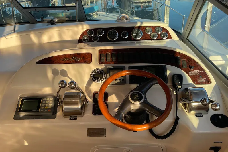 Slide: The Image of Cockpit of 1998 Sea Ray 310 boat with wooden steering wheel and control panel. - 7