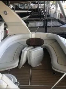 Slide: The Image of 1998 Sea Ray 310 boat interior with white seating and wooden table. - 8