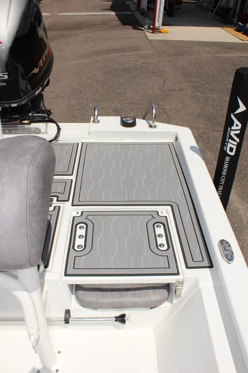 Slide: The Image of 2024 Avid 19 FSX boat deck with gray non-slip surface and seating. - 10