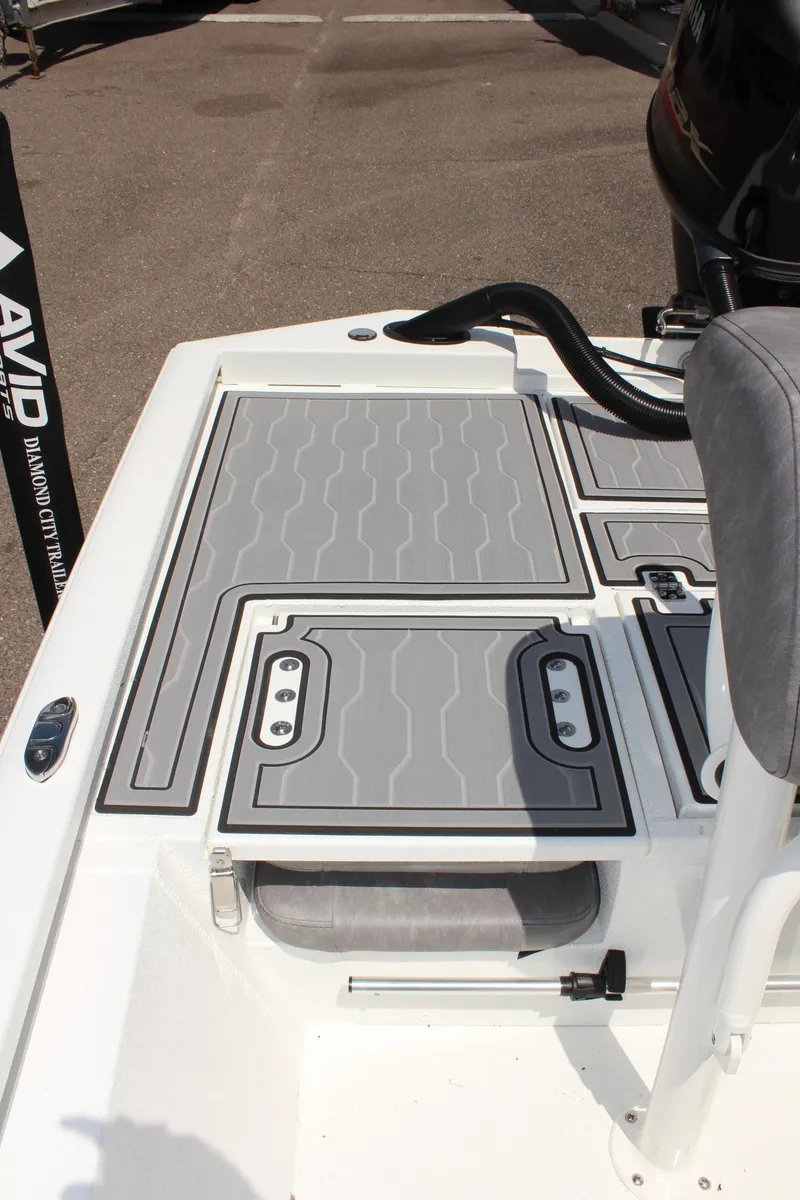 Slide: The Image of 2024 Avid 19 FSX boat deck with gray non-slip surface and seating. - 13