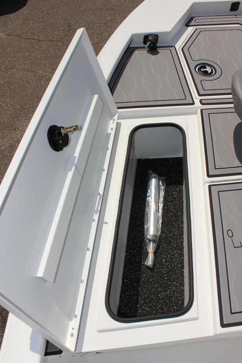 Slide: The Image of 2024 Avid 19 FSX boat storage compartment with secure latch and interior padding. - 24