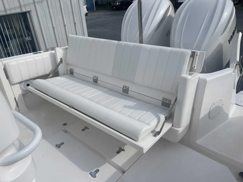 Slide: The Image of 2013 Intrepid 327 Cuddy boat with white cushioned seating and dual outboard engines. - 22