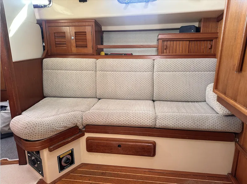Slide: The Image of 2001 Island Packet 320 interior with cushioned seating and wooden cabinetry. - 14