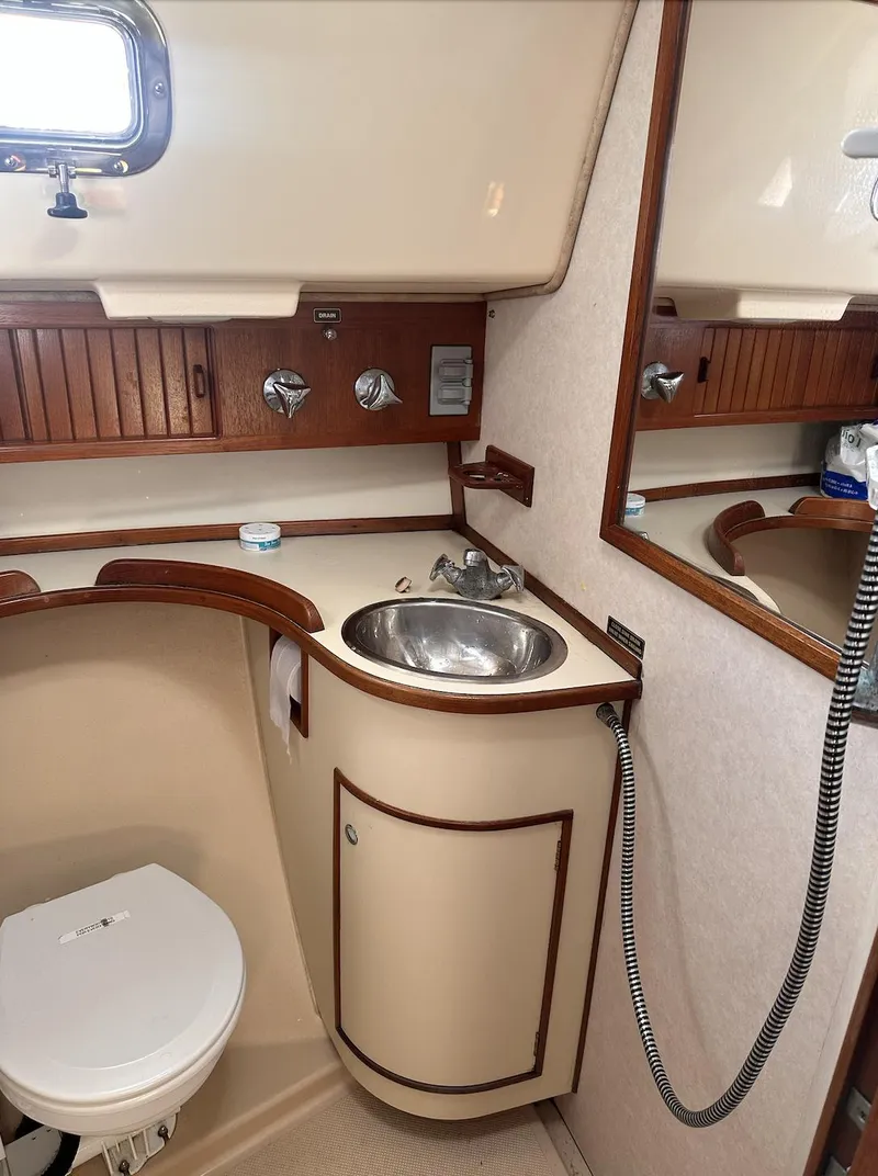 Slide: The Image of 2001 Island Packet 320 yacht bathroom with sink, toilet, and mirror. - 15