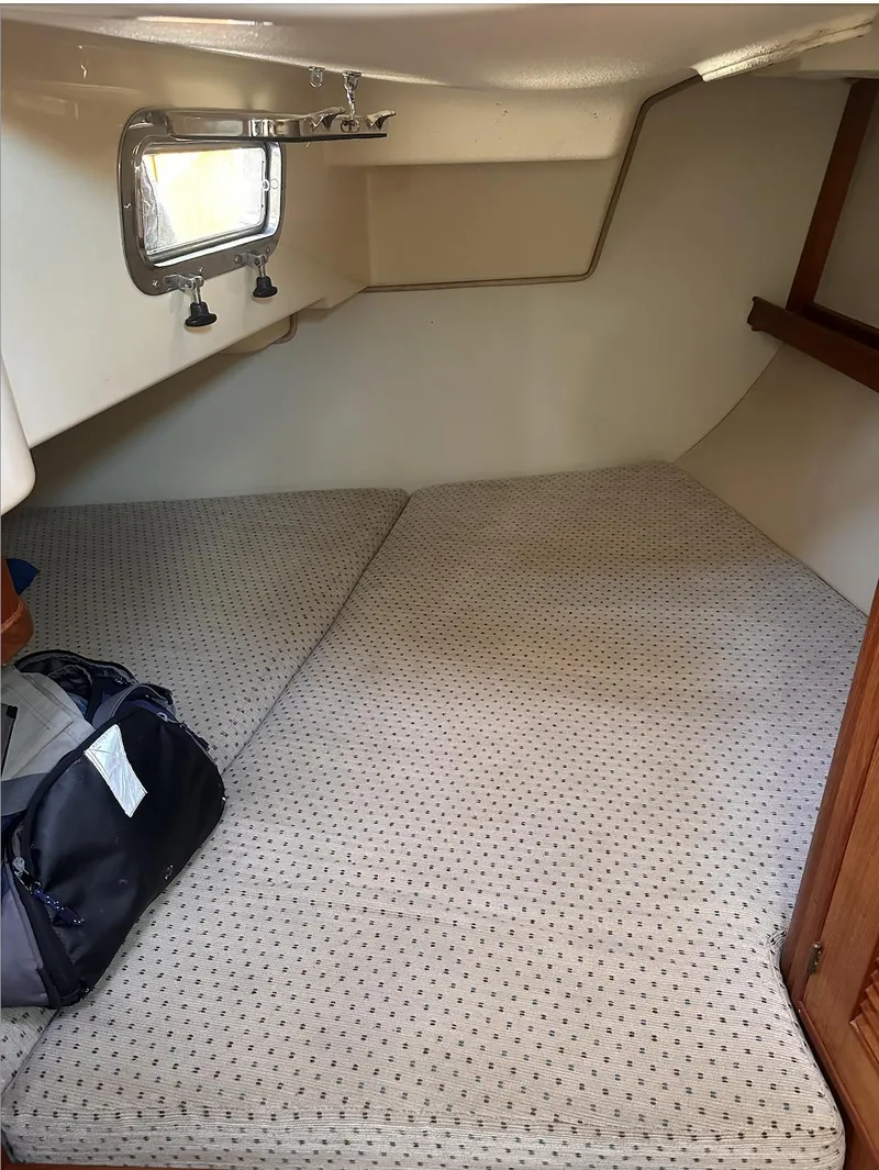 Slide: The Image of 2001 Island Packet 320 cabin interior with bed and porthole window. - 16