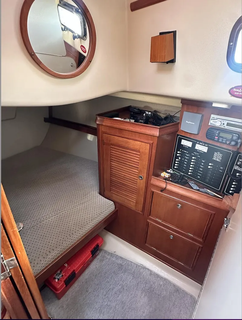 Slide: The Image of Interior cabin of 2001 Island Packet 320 sailboat with wood cabinetry and navigation equipment. - 18