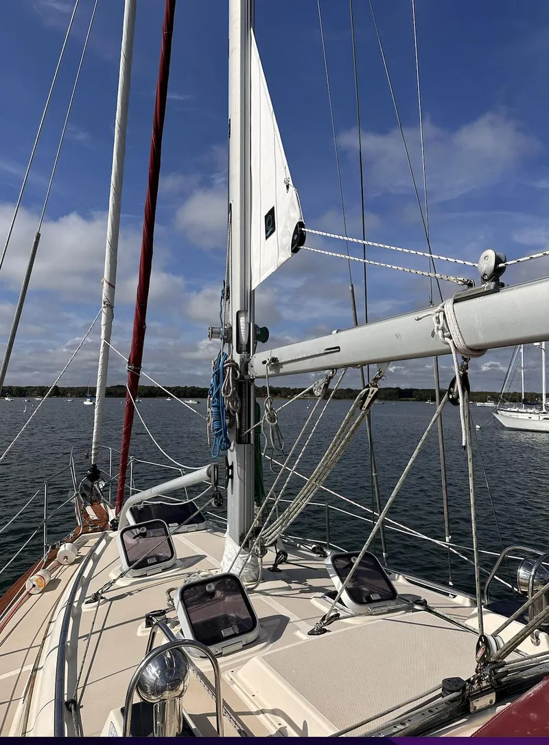 Slide: The Image of 2001 Island Packet 320 sailboat deck with mast and rigging under blue sky. - 2