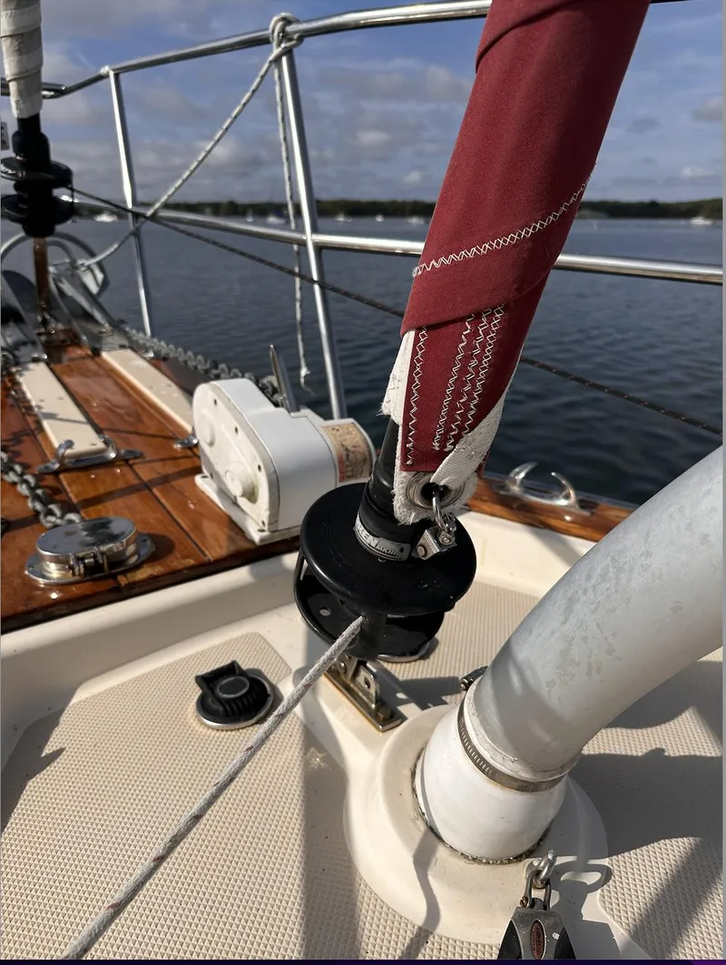 Slide: The Image of 2001 Island Packet 320 sailboat deck with rigging and winch, sailing on calm waters. - 7