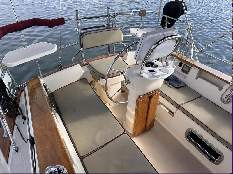 Slide: The Image of Cockpit of 2001 Island Packet 320 sailboat with cushioned seating and steering wheel. - 8