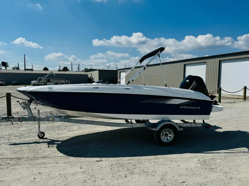 The Image of 2025 Bayliner Element E18 boat on trailer, parked outdoors under a clear sky. - 1