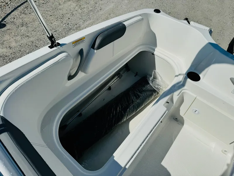 Slide: The Image of 2025 Bayliner Element E18 boat interior storage compartment, white finish, open hatch. - 12