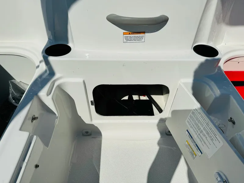 Slide: The Image of 2025 Bayliner Element E18 boat storage compartment with open hatch and cup holders. - 13