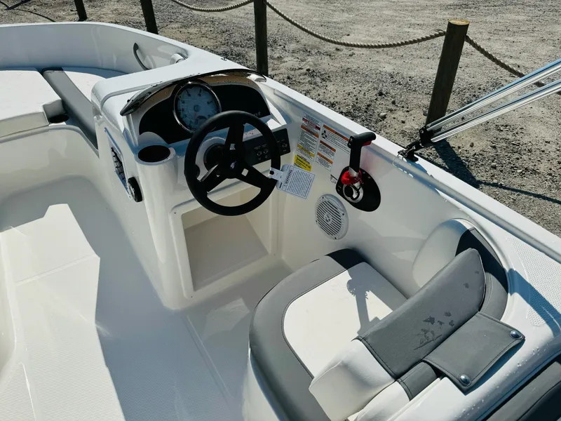 Slide: The Image of 2025 Bayliner Element E18 boat interior with steering wheel and seating. - 16