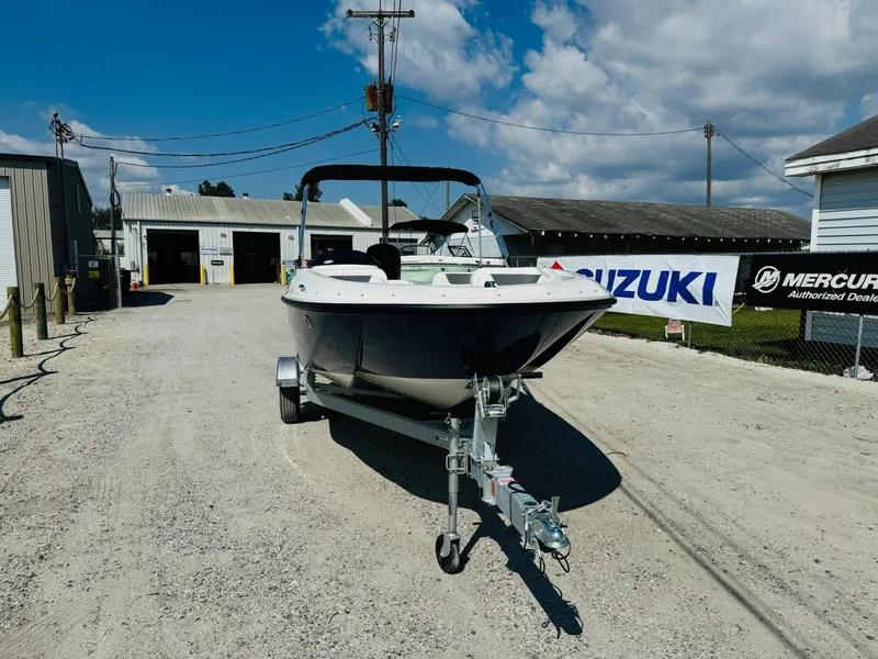 Slide: The Image of 2025 Bayliner Element E18 boat on trailer, parked outdoors under a clear blue sky. - 3