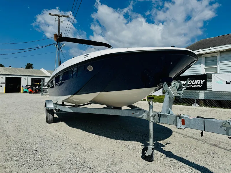 Slide: The Image of 2025 Bayliner Element E18 boat on trailer, parked outdoors under a blue sky. - 4