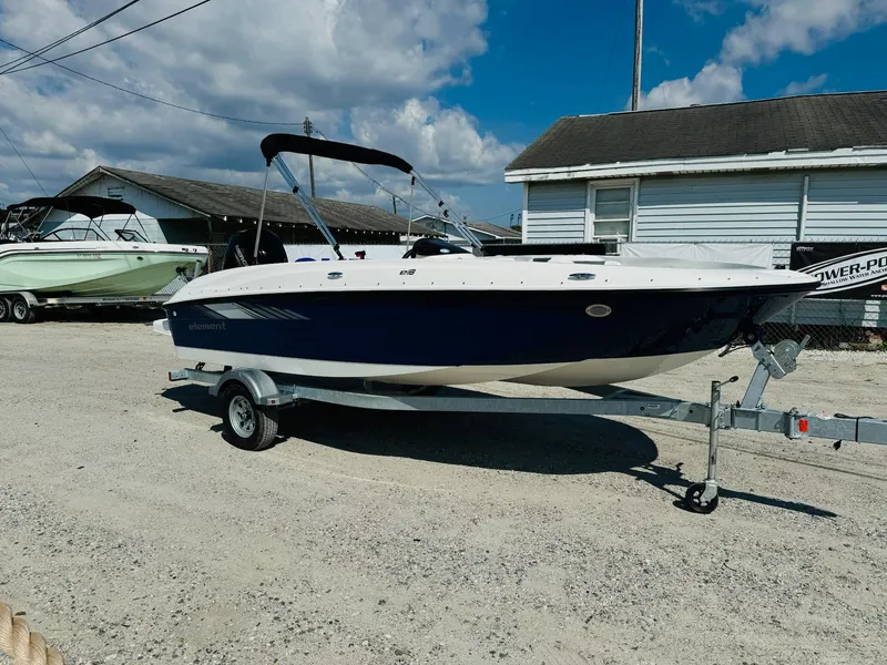 Slide: The Image of 2025 Bayliner Element E18 boat on trailer, parked outdoors under a cloudy sky. - 5