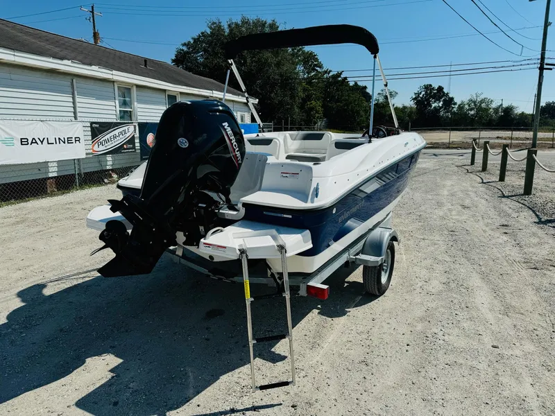 Slide: The Image of 2025 Bayliner Element E18 boat on trailer, parked outdoors, with visible outboard motor. - 7