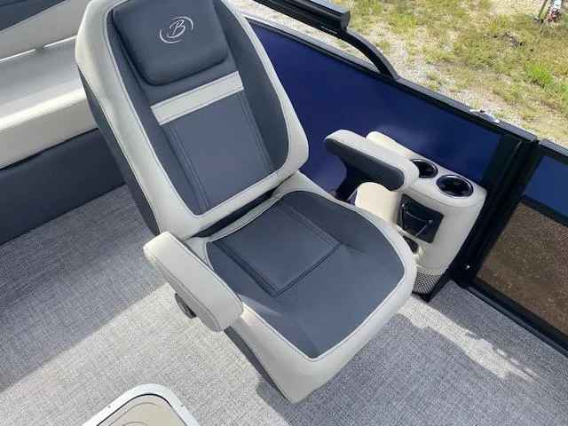 Slide: The Image of Captain's chair in 2023 Barletta Cabrio 24 UC pontoon boat, featuring cup holders and armrests. - 13