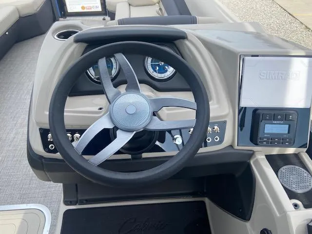 Slide: The Image of 2023 Barletta Cabrio 24 UC boat dashboard with steering wheel and control panel. - 17