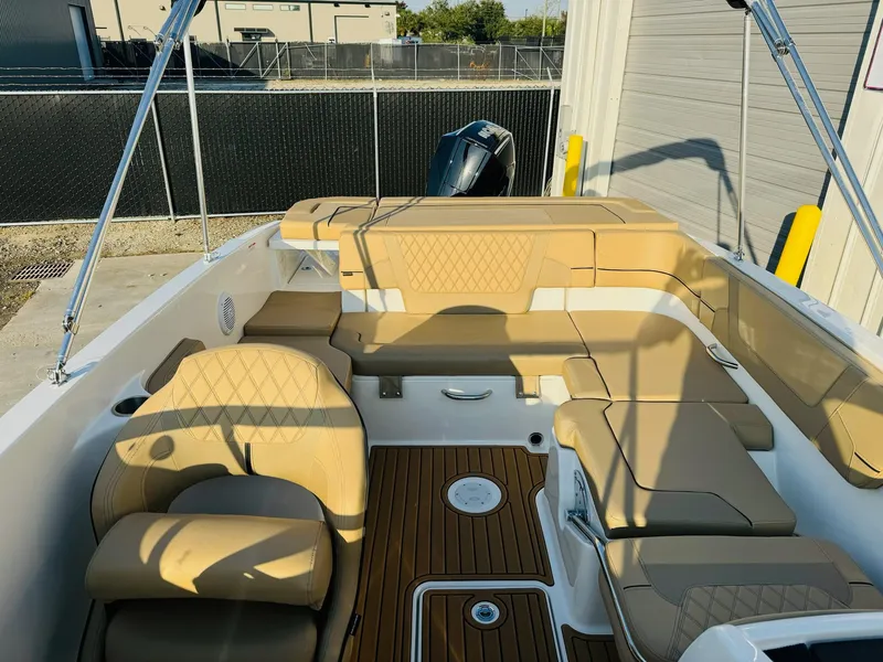 Slide: The Image of 2025 Bayliner VR6 Bowrider OB with tan seating and wood accents, docked outdoors. - 12