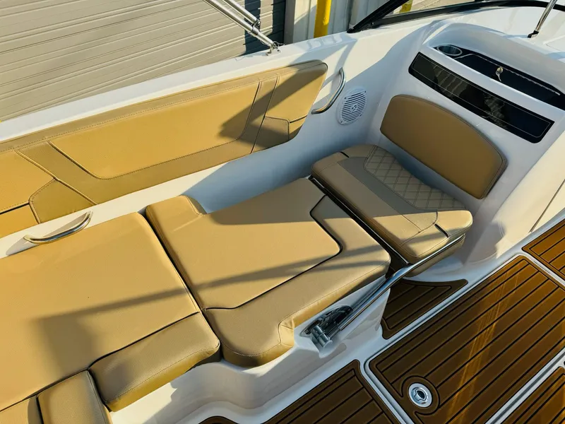 Slide: The Image of 2025 Bayliner VR6 Bowrider OB interior with tan seating and wood-style flooring. - 16