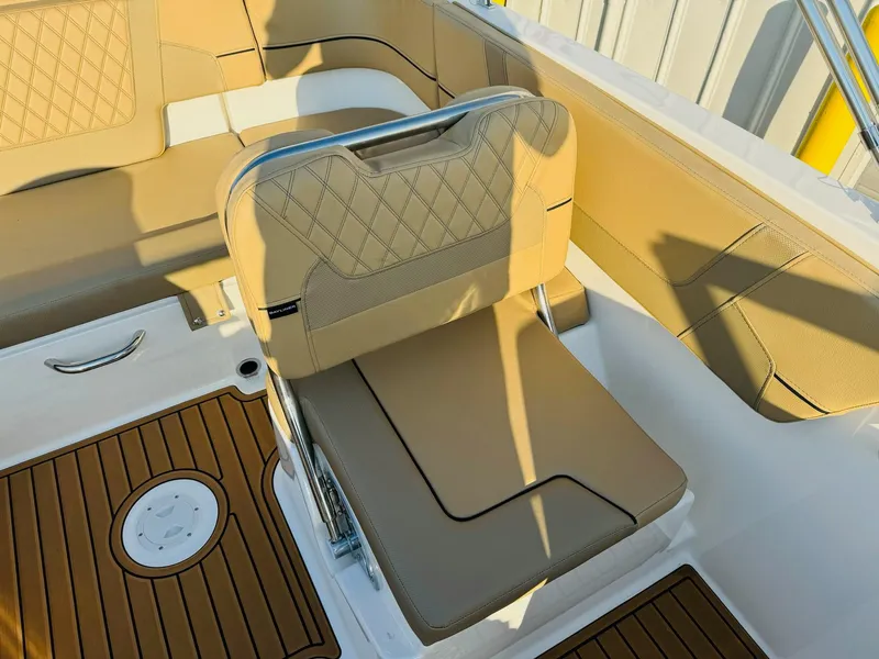 Slide: The Image of 2025 Bayliner VR6 Bowrider OB interior with tan seating and wood-style flooring. - 18