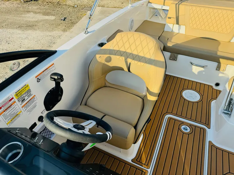 Slide: The Image of 2025 Bayliner VR6 Bowrider OB interior with tan seating and wood-style flooring. - 20