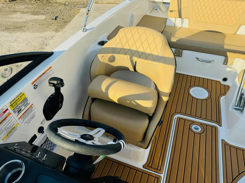 Slide: The Image of 2025 Bayliner VR6 Bowrider OB interior with tan seating and wood-style flooring. - 21