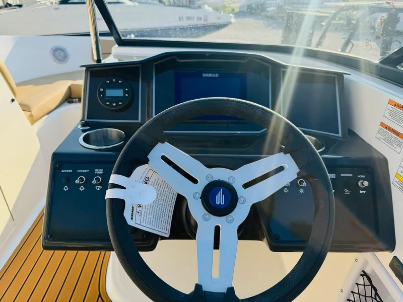 Slide: The Image of 2025 Bayliner VR6 Bowrider OB dashboard with steering wheel and control panel. - 22