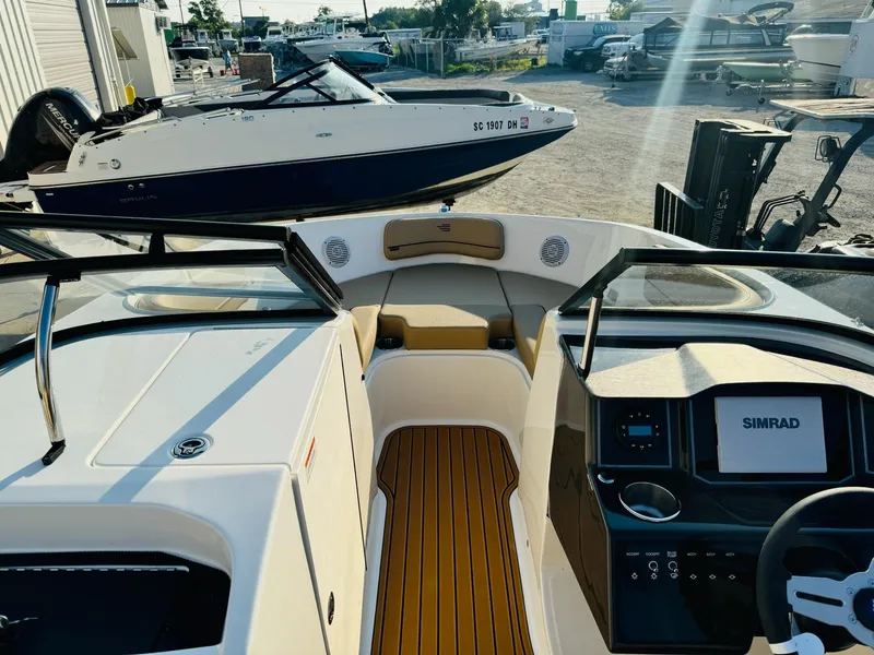 Slide: The Image of 2025 Bayliner VR6 Bowrider OB interior with Simrad display, docked in a marina. - 28