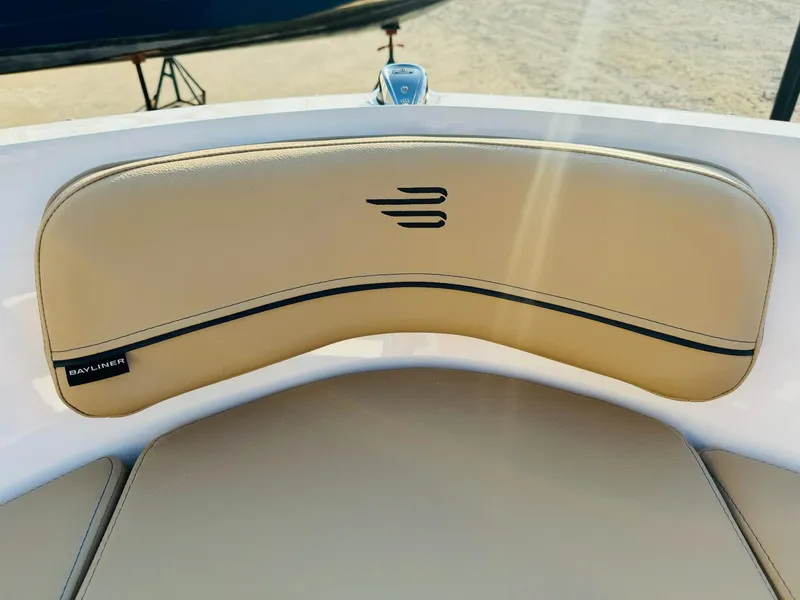 Slide: The Image of 2025 Bayliner VR6 Bowrider OB, tan seating detail with logo, outdoor setting. - 31