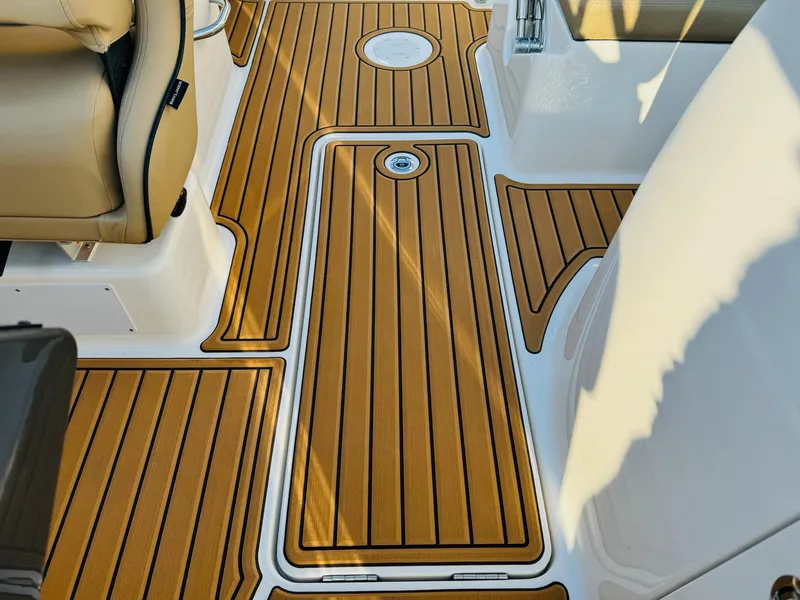 Slide: The Image of 2025 Bayliner VR6 Bowrider OB interior with teak-style flooring and beige seating. - 35