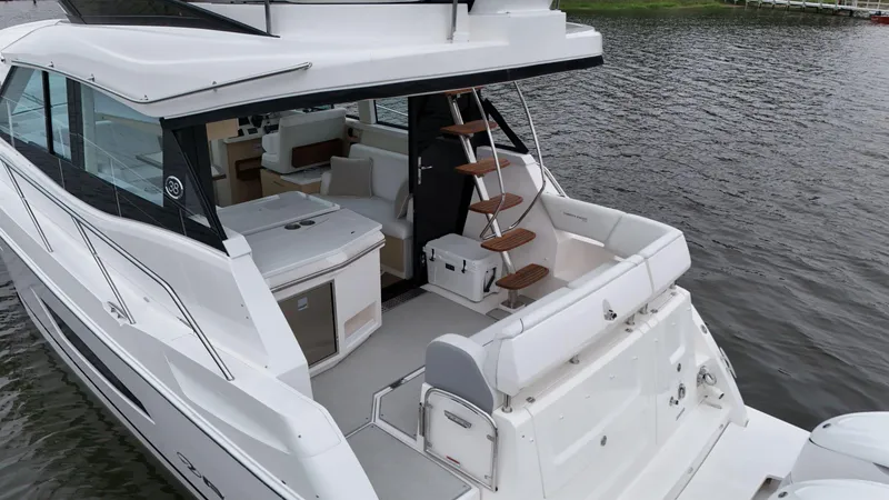 Slide: The Image of 2025 Regal 38 FXO luxury yacht with spacious deck and modern interior on calm water. - 10