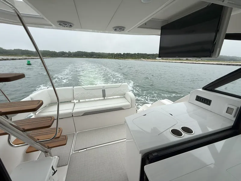 Slide: The Image of 2025 Regal 38 FXO yacht interior with seating, stairs, and water view. - 12