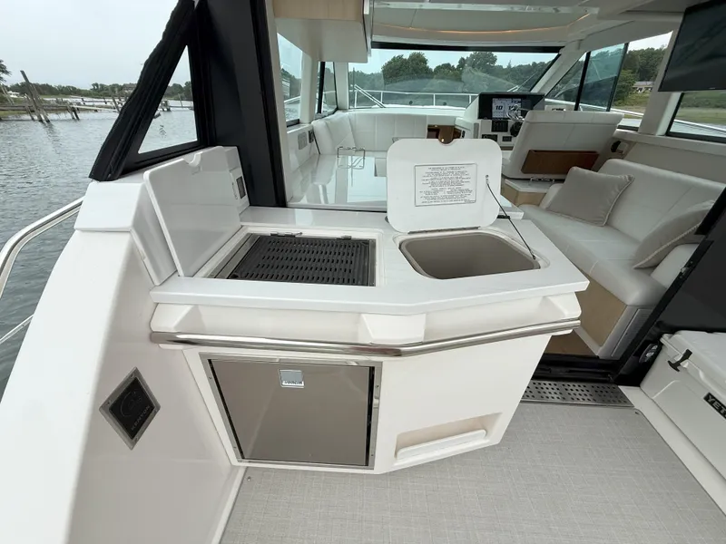 Slide: The Image of Luxurious 2025 Regal 38 FXO yacht interior with kitchenette and seating area. - 13