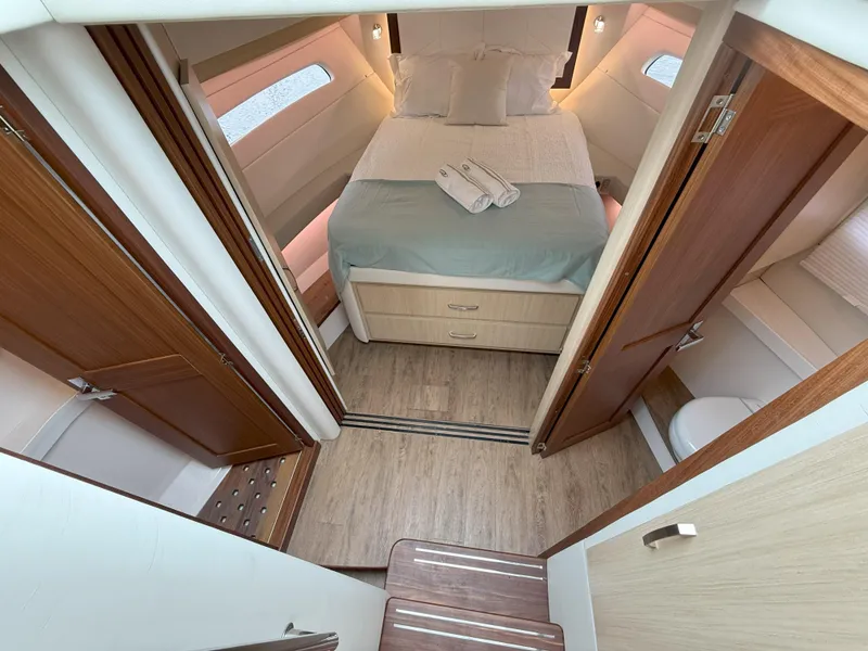Slide: The Image of Luxurious cabin interior of 2025 Regal 38 FXO yacht with cozy bed and wooden finishes. - 31