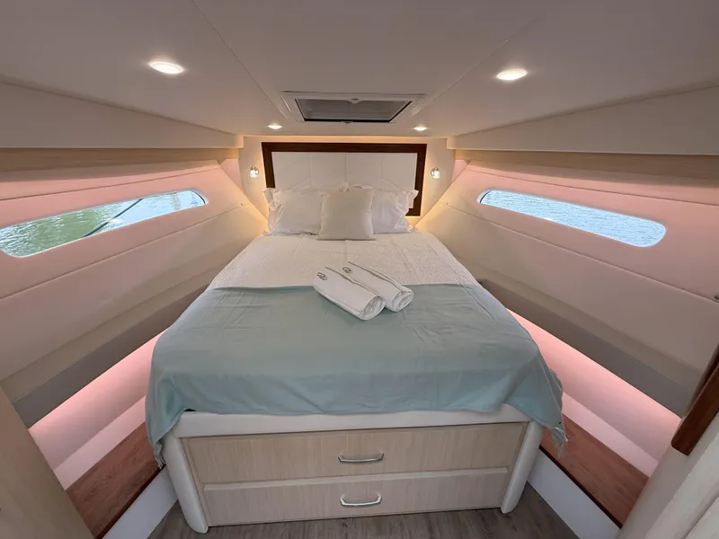 Slide: The Image of Luxurious cabin interior of 2025 Regal 38 FXO yacht with cozy bed and ambient lighting. - 32
