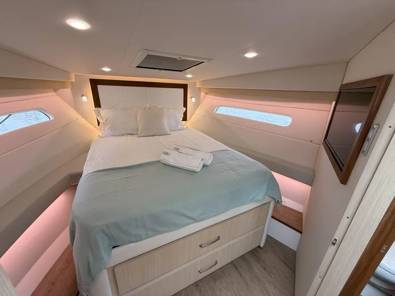 Slide: The Image of Luxurious cabin interior of 2025 Regal 38 FXO yacht with cozy bed and ambient lighting. - 33