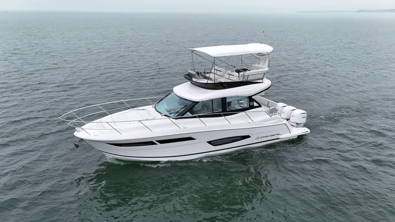 Slide: The Image of 2025 Regal 38 FXO yacht cruising on open water. - 4