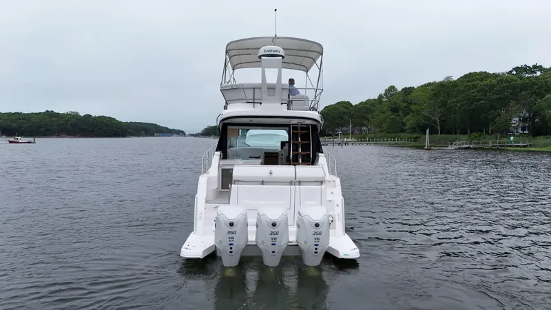 Slide: The Image of 2025 Regal 38 FXO boat with triple 350 engines on a calm river. - 7