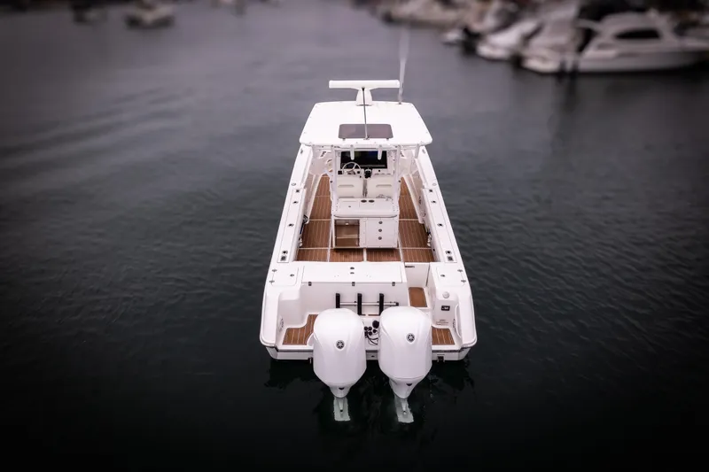 Slide: The Image of 2017 Edgewater Center Console boat on calm water, rear view. - 17