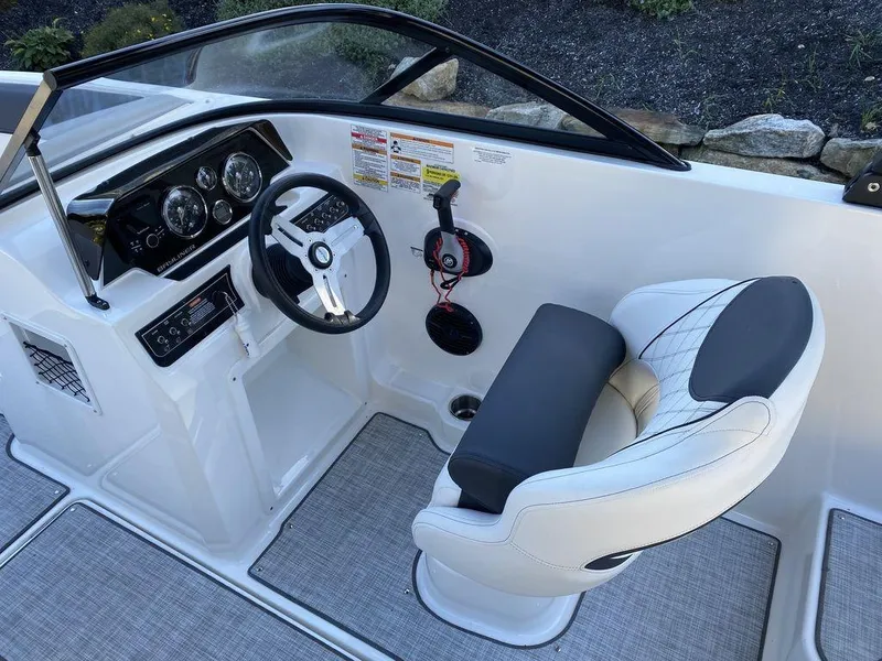 Slide: The Image of 2023 Bayliner DX2050 boat cockpit with steering wheel and captain's chair. - 13